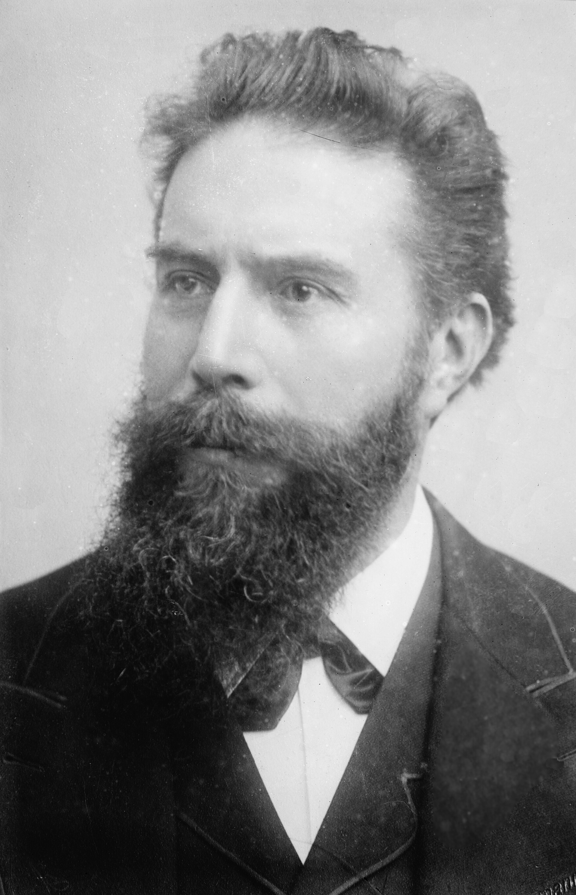 Retrato fotográfico de Wilhelm Röntgen, con barba, de medio cuerpo